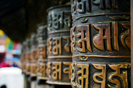 Row of tibetan prayer wheels with inscriptions