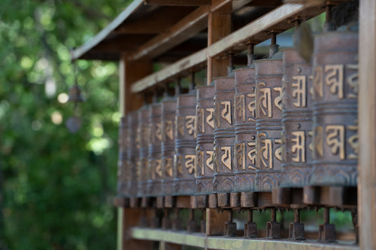 Row of tibetan prayer wheels with script