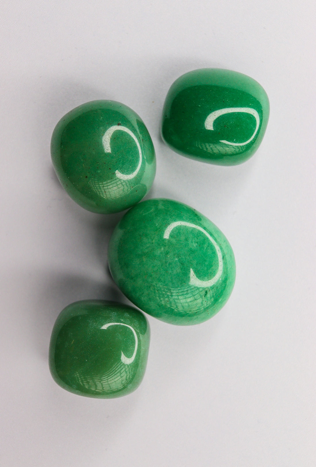 Four green candies with white c letters.