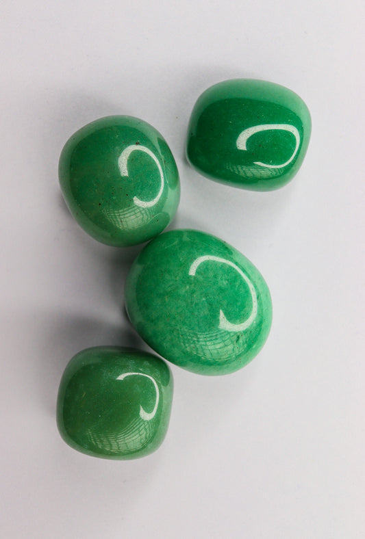 Four green candies with white c letters.